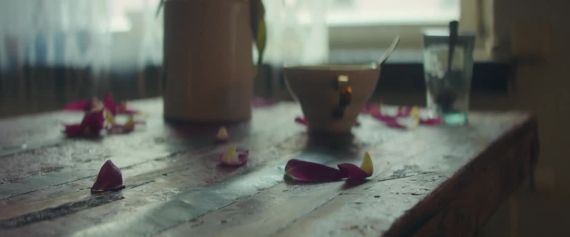 Flower petals on a table with drinks on it in a home