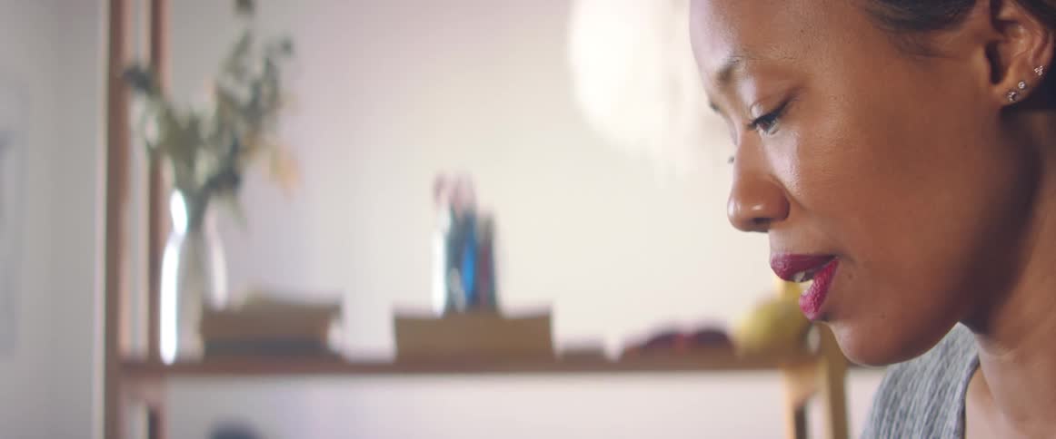 A woman stands in her apartment watching something