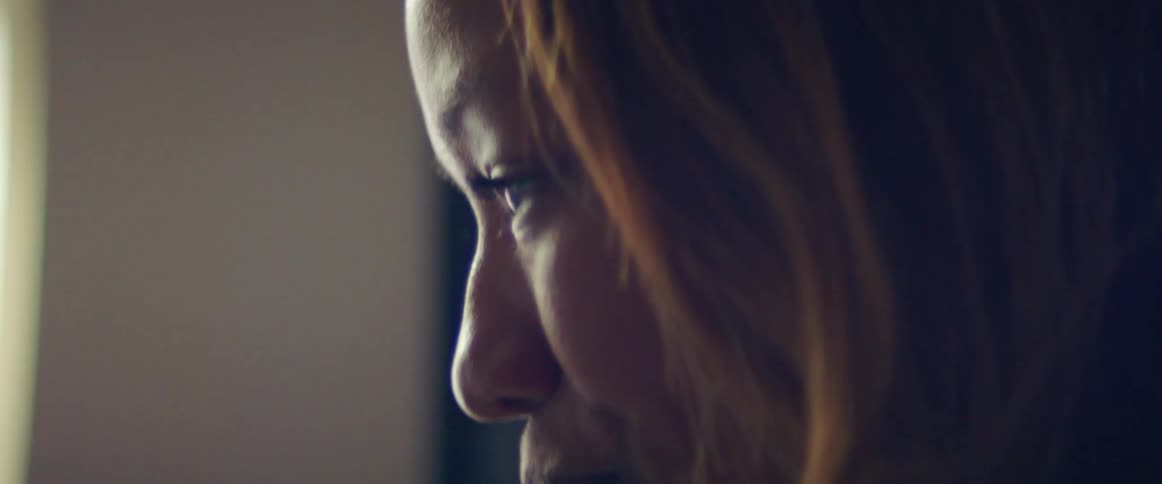 Close up of the face of a woman sitting in a room