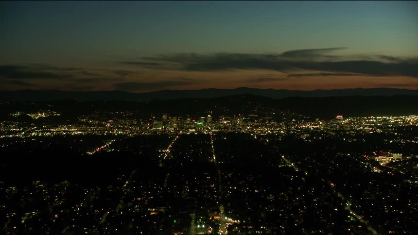 Stunning time lapse aerial shot of Portland Oregon flying directing into downtown with traffic streaming in and out of the city with stunning sunset clouds and colors
