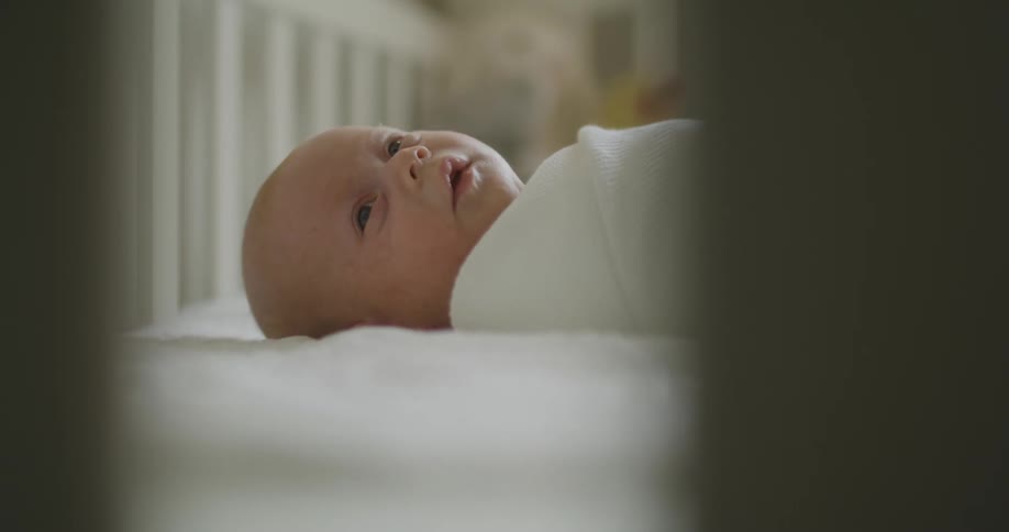 A baby laying in a crib napping