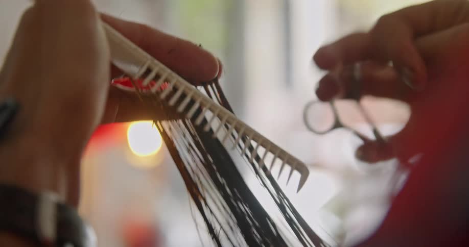 Close up of a person cutting hair in a salon