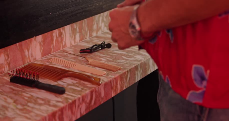 A man places combs and other items on the counter