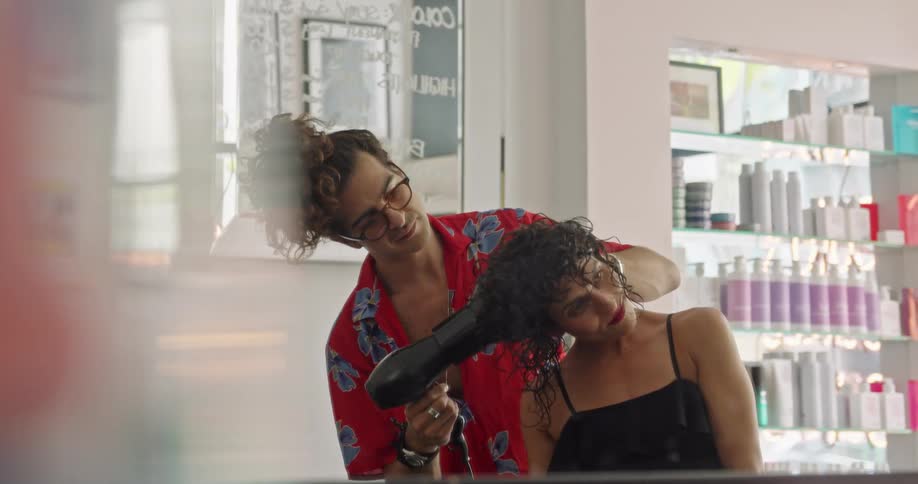 Hair stylist drying customer hair