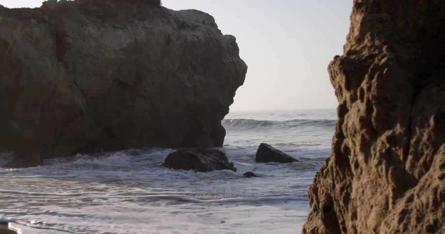 Waves crash against rocks and the beach