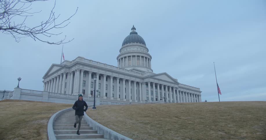 A man runs down the steps of a government building