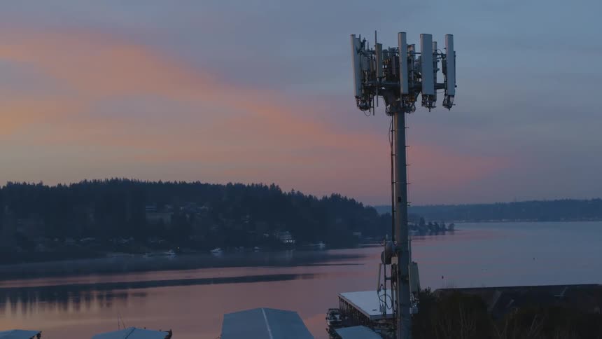 A cell tower working near a lakeshore community at sunrise