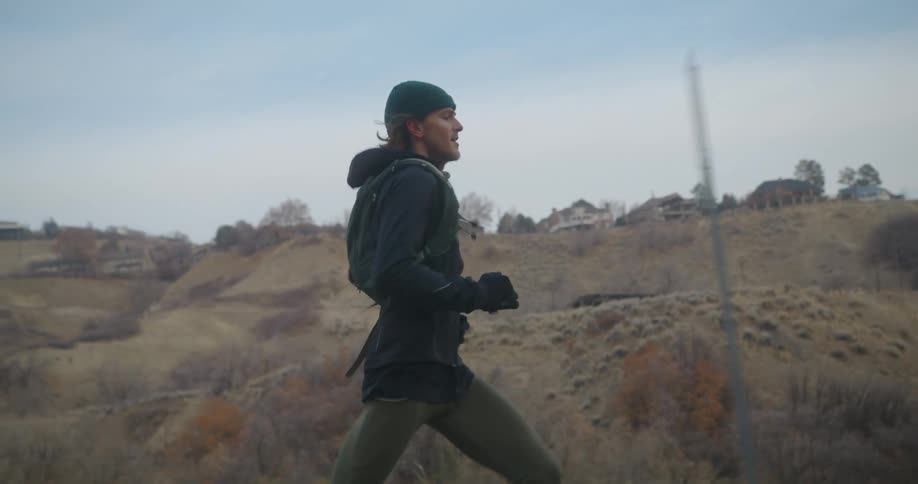 A man runs on a rural road with his dog