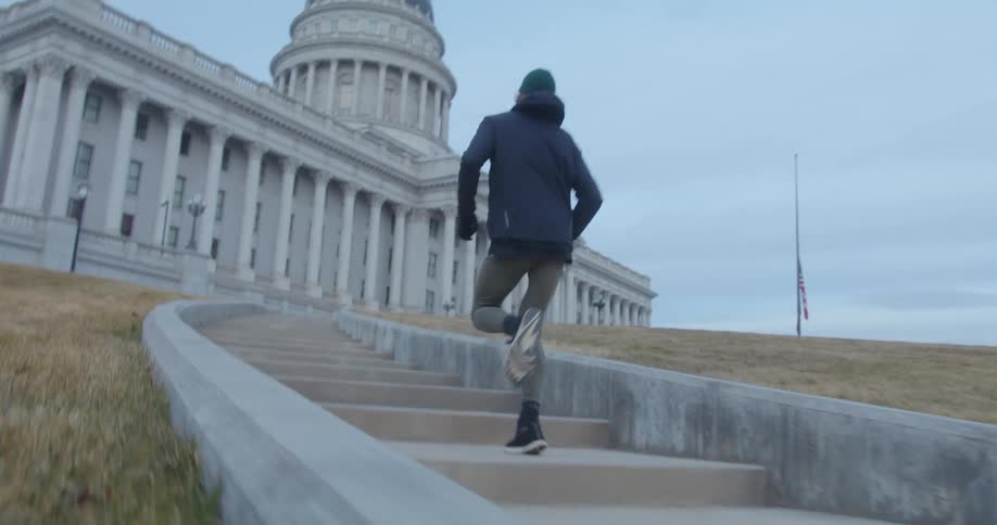 A man is running up the steps with a dog