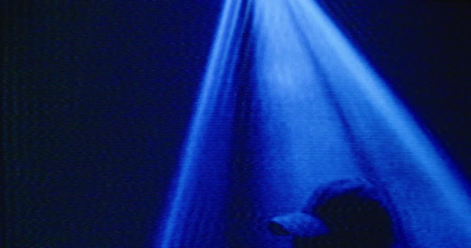 Fuzzy film footage of a man playing drums on a stage