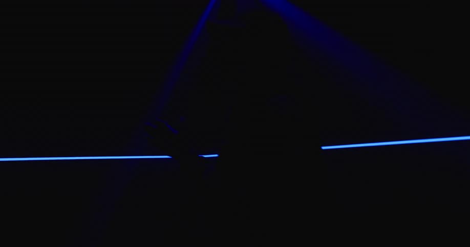 A man is dancing in a room with flashing lights