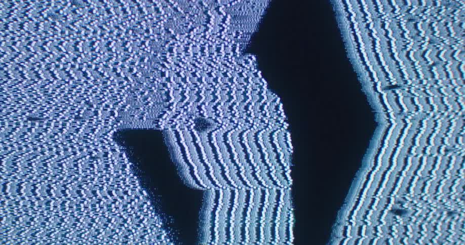 Silhouette of a man standing in front of a spinning cube with video distorsions and static