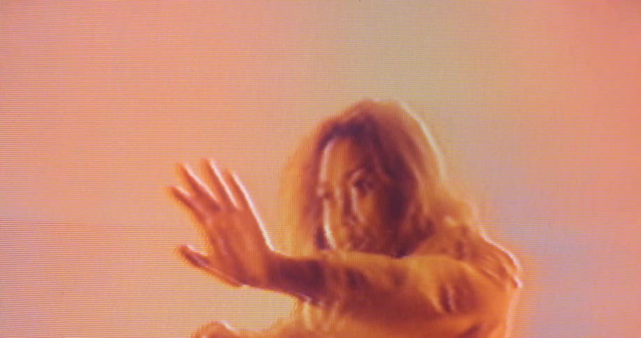 A woman dancing in front of a screen