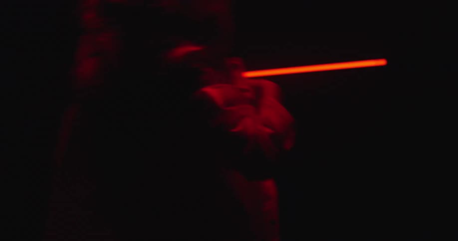 A woman spinning and dancing in front of a glowing red light