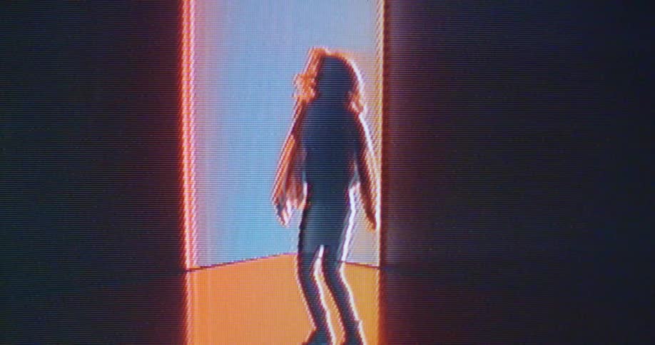 The silhouette of a woman dancing with lights projected static and jumping