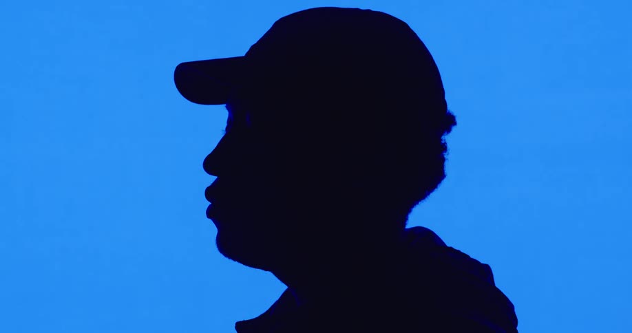 A man is wearing a hat and standing in a room