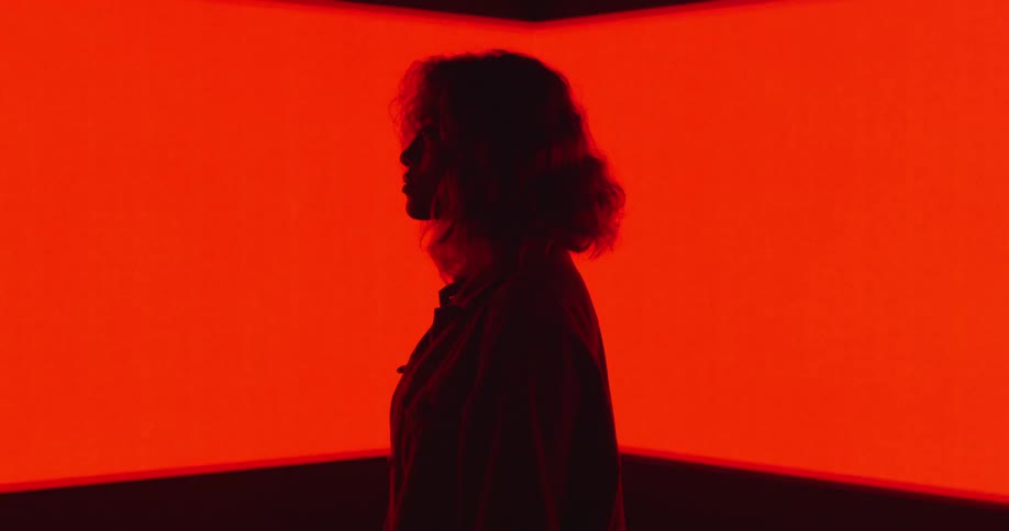 A woman is standing in front of a moving light