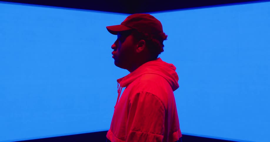 The wall flashes blue behind the man