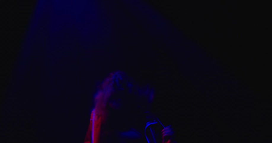 A person is dancing in a room with flashing lights