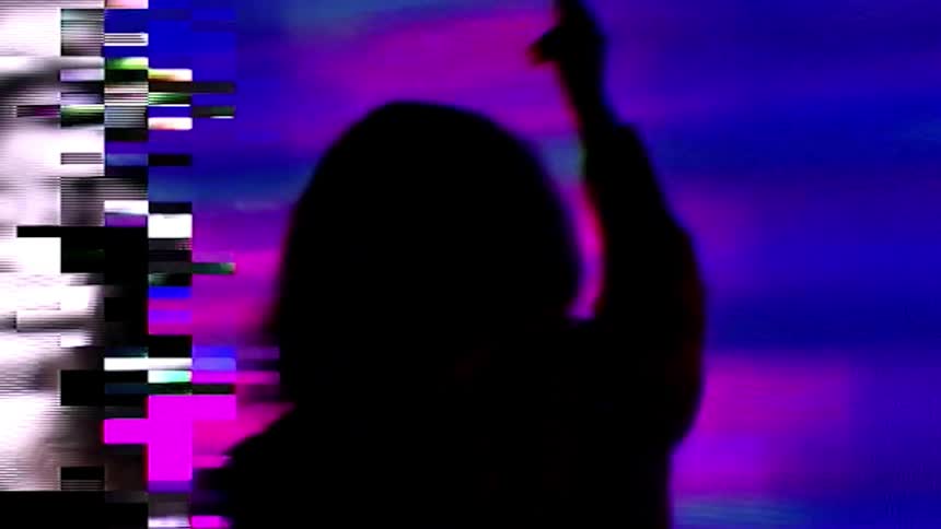 A woman in a room with a screen in the background