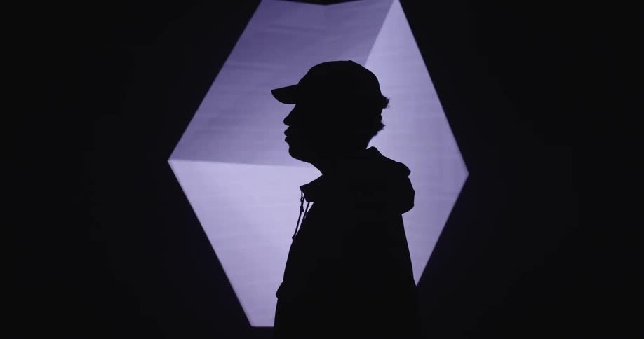 A silhouette man in front of a rotating digital cube