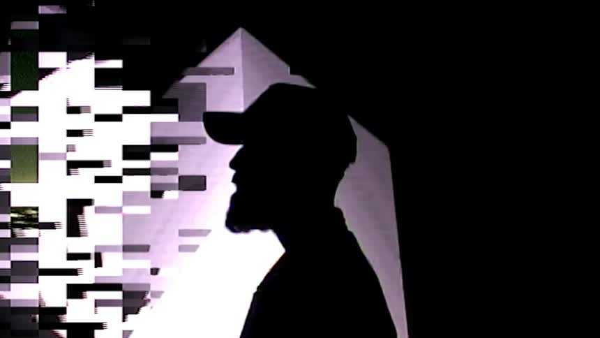 A man is standing in a room and wearing a hat
