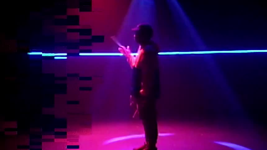 A man spinning drum sticks on a stage
