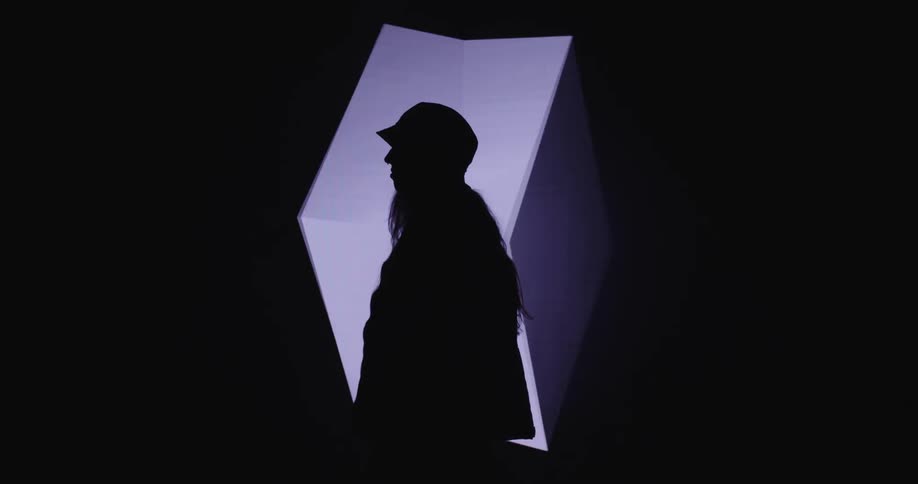 A woman is standing and wearing a hat