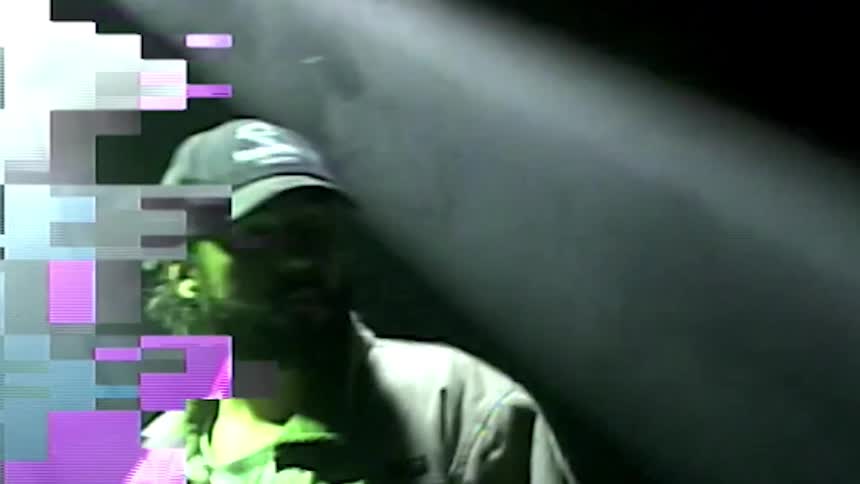 A man standing on stage with lights above him