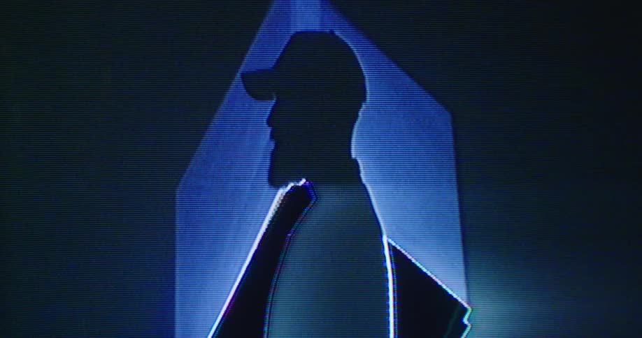 A silhouette of a man standing in front of a cube