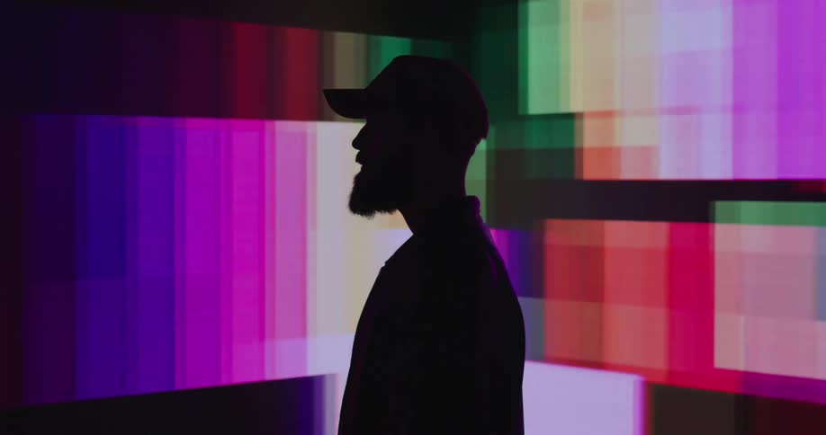 Colorful pixel squares projected behind the silhouette of a man in profile