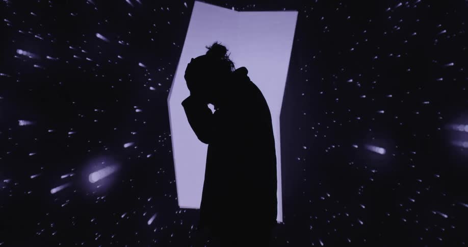 A man is posing in front of a digital display