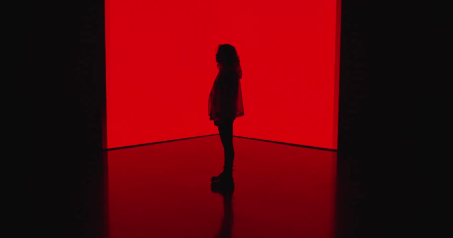 A woman standing on a bright red stage