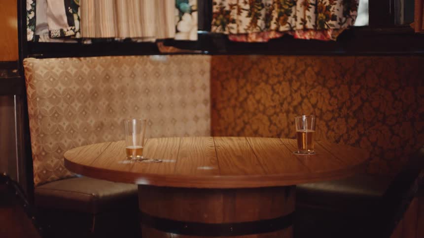 Lights dance across booth and round table holding two beers