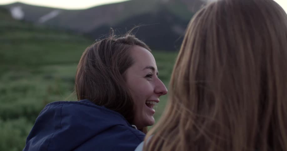 Two girls talk and laugh together