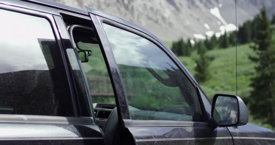 Person closing the passenger side door of a vehicle after getting inside
