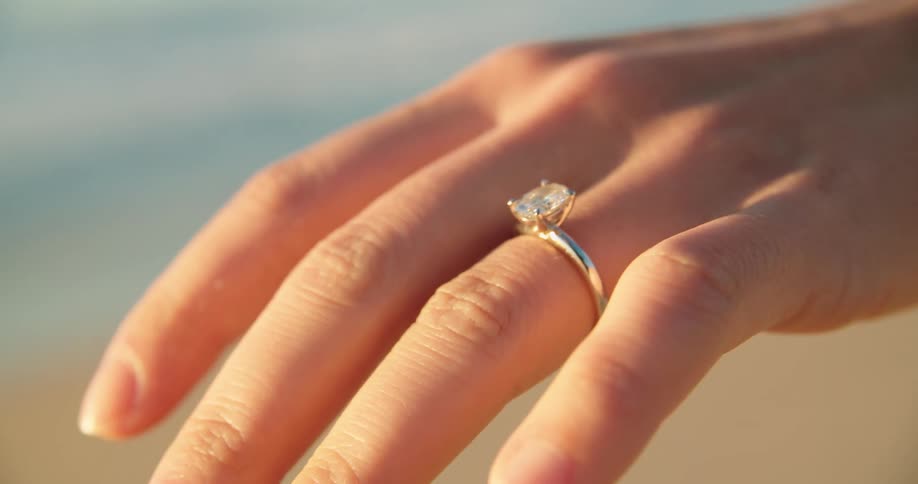 Womans left hand with a diamond ring on her finger