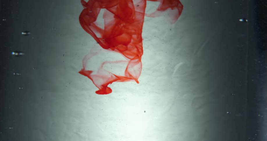 Red dye mixes in to water with rising bubbles