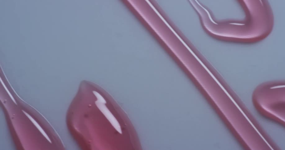 Streams of pink syrup on a flat surface