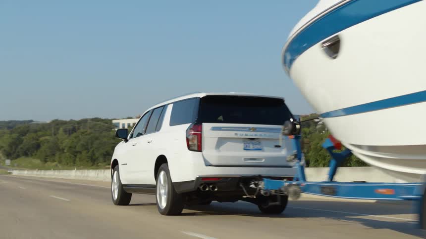 Car towing a boat on the highway crossing a bridge at morning