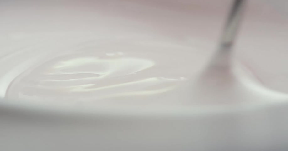 White cream being stirred in a bowl