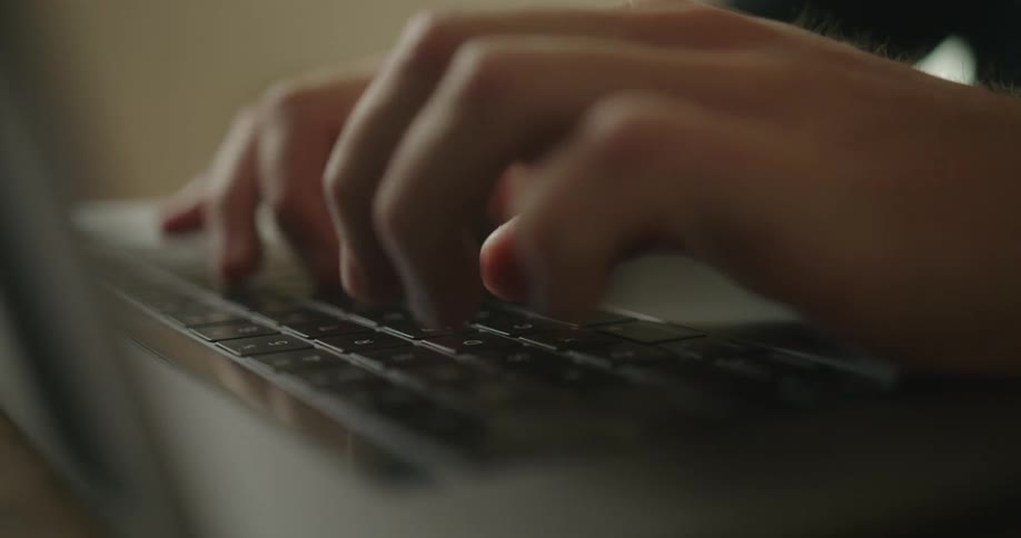 Fingers are typing on a laptop computer keyboard