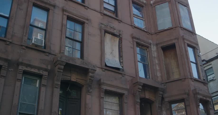 Police patrol car parked in front of a decrepit building in the city