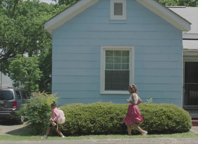 Mother and daughter running to the car parked next to the house