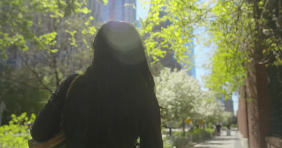 A woman walking outdoors on a sidewalk