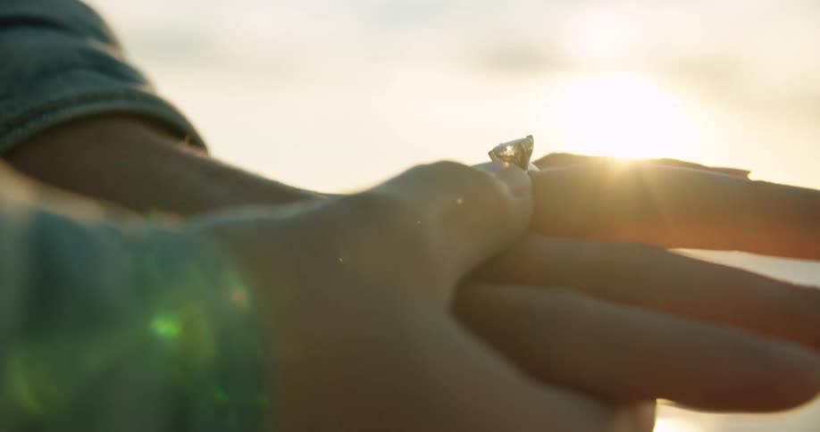 Woman displays a diamond engagement ring on her left hand