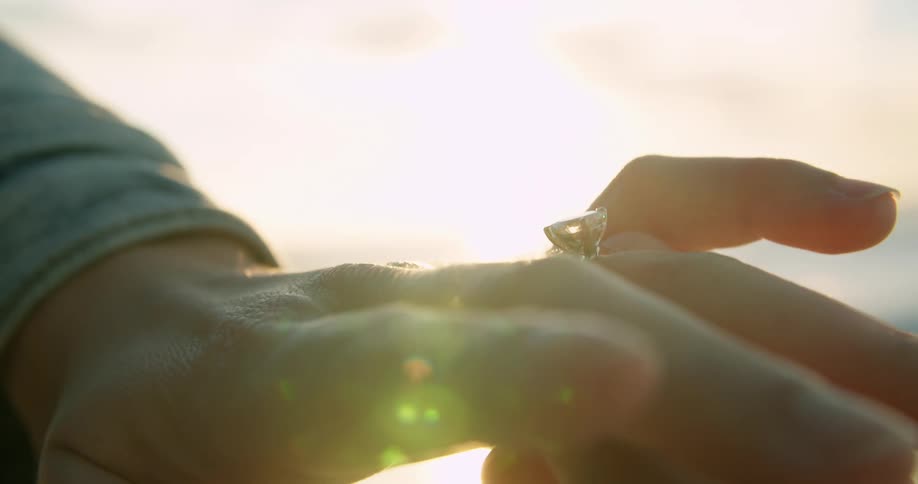 A person places a wedding ring on a finger