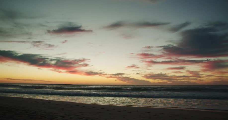 Ocean tide washes onto the beach at sunset