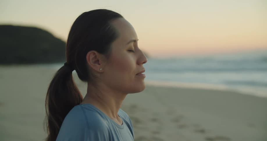 A woman is standing outdoors at the coast