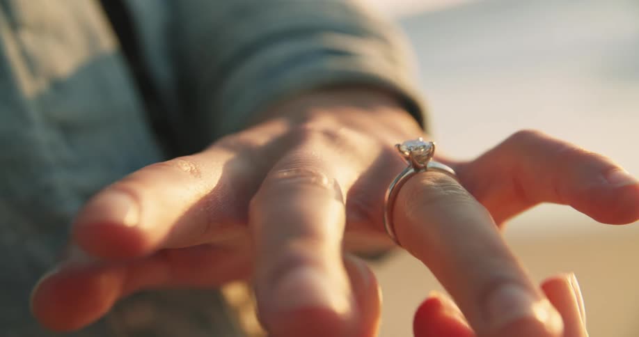 A girlfriend putting on an engagement ring